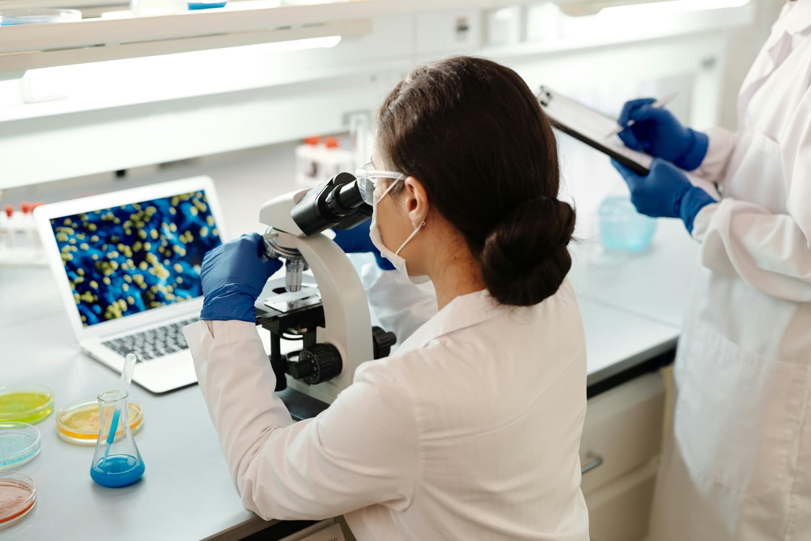 Laboratory scientist reviewing a sample through a microscope